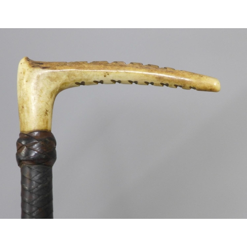 816 - A 19th Century hawthorn walking cane, with carved hunting related top and a riding crop with antler ... 