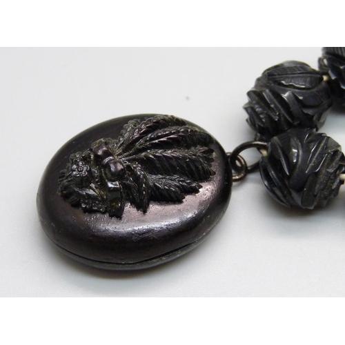 934 - A Victorian carved jet bead necklace with locket