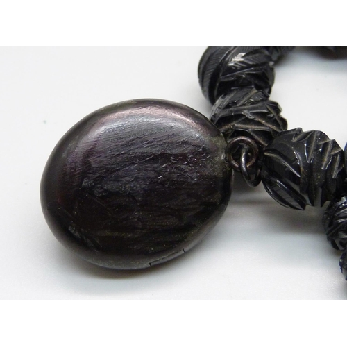 934 - A Victorian carved jet bead necklace with locket