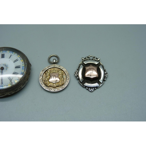 939 - A silver pocket watch, 4cm case, and two gold fronted silver fob medals