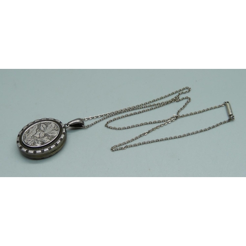 944 - A Victorian silver engraved locket on a silver chain, Birmingham 1882, 21mm wide