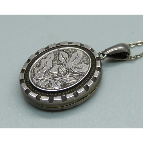 944 - A Victorian silver engraved locket on a silver chain, Birmingham 1882, 21mm wide