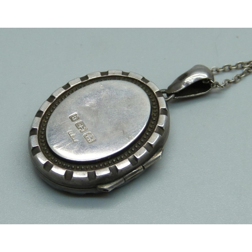 944 - A Victorian silver engraved locket on a silver chain, Birmingham 1882, 21mm wide