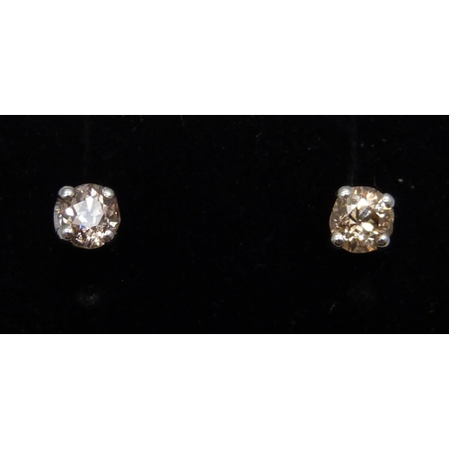 976 - A pair of 18ct white gold and diamond set stud earrings, total diamond weight 0.64cts