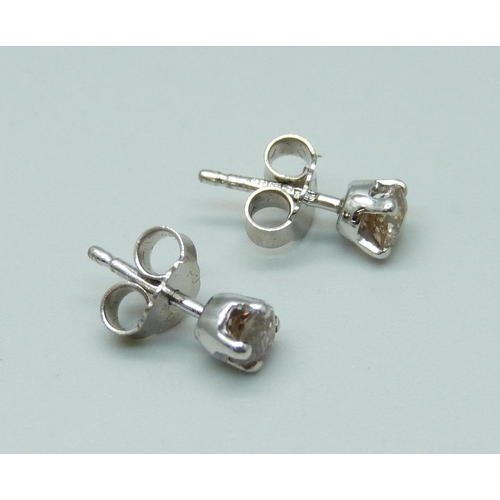 976 - A pair of 18ct white gold and diamond set stud earrings, total diamond weight 0.64cts