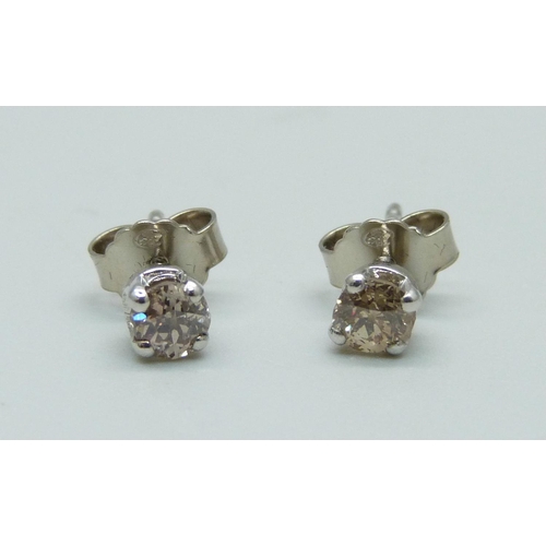 976 - A pair of 18ct white gold and diamond set stud earrings, total diamond weight 0.64cts