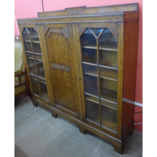 108 - An early 20th Century carved oak three door bookcase