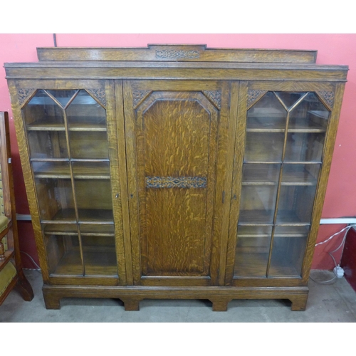 108 - An early 20th Century carved oak three door bookcase