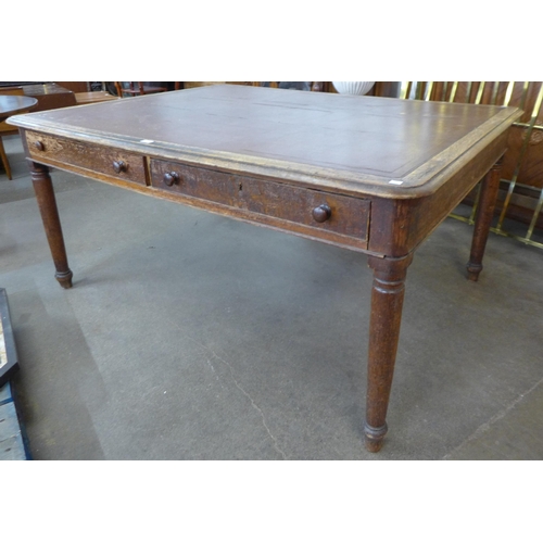 119 - A Victorian oak and faux leather topped double sided four drawer library table