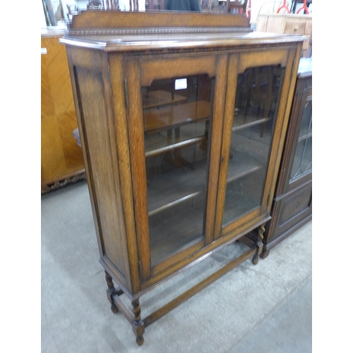 127 - An early 20th Century oak two door barleytwist bookcase