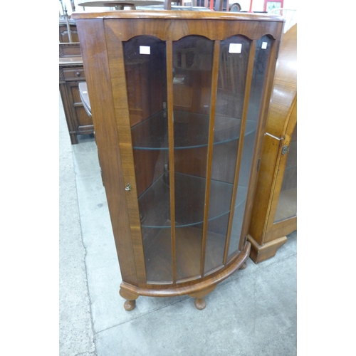 129 - A walnut bow front corner display cabinet