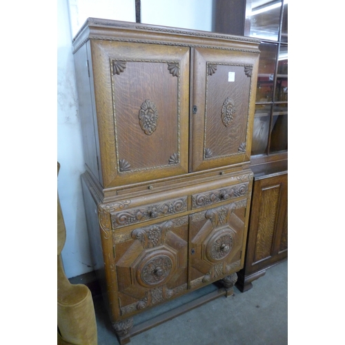 140 - An early 20th Century Jacobean Revival carved oak cocktail cabinet