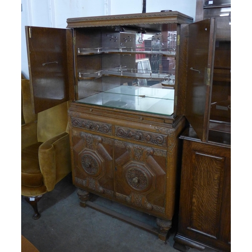 140 - An early 20th Century Jacobean Revival carved oak cocktail cabinet