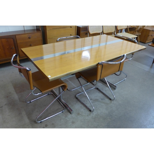 15 - A teak and chrome dining table and four chrome and brown faux leather cantilever chairs