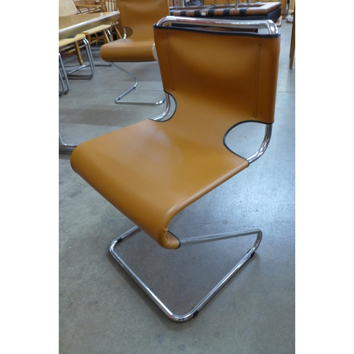 15 - A teak and chrome dining table and four chrome and brown faux leather cantilever chairs