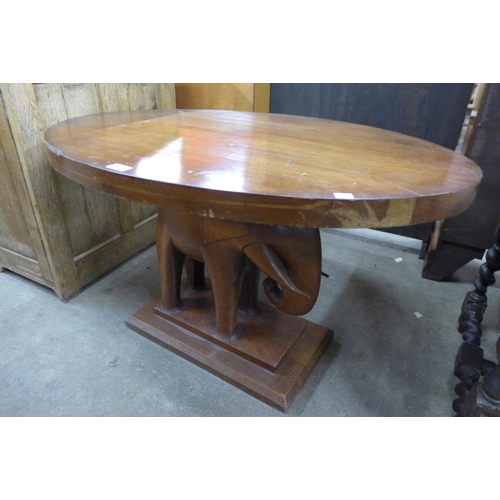 155 - An African carved mahogany elephant based oval coffee table