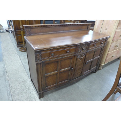 157 - An oak seven piece dining suite, comprising; draw leaf table, four chairs and a sideboard