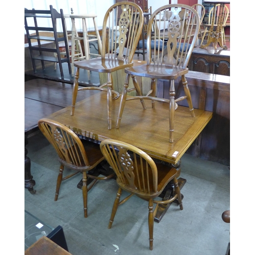 191 - A carved oak draw leaf refectory table and four beech wheelback chairs