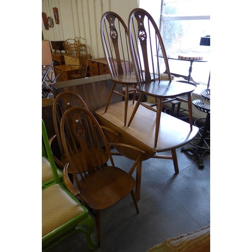 214 - An Ercol Golden Dawn elm and beech Windsor drop leaf table and four chairs