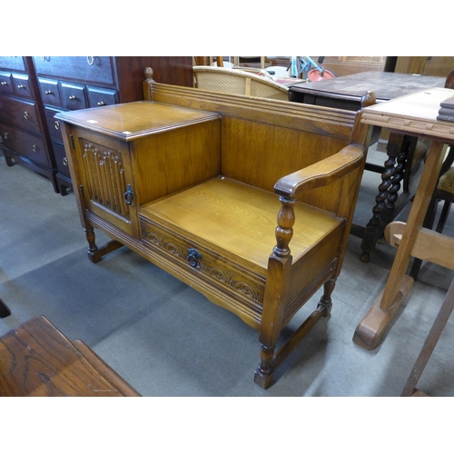 221 - A carved oak linenfold telephone seat