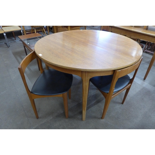 26 - A Nathan teak circular extending dining table and four chairs