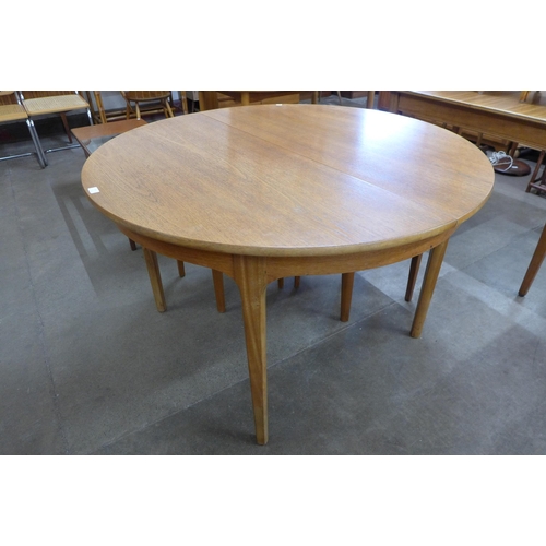 26 - A Nathan teak circular extending dining table and four chairs