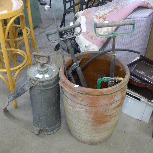 280 - A terracotta chimney-pot, two vintage stirrup pumps and a copper sprayer