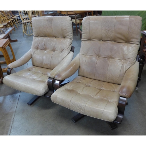 40 - A pair of Scandinavian bent beech wood and leather revolving lounge chairs. Please note this lot is ... 