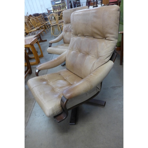 40 - A pair of Scandinavian bent beech wood and leather revolving lounge chairs. Please note this lot is ... 