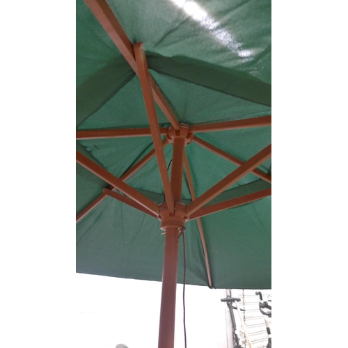 2277 - A green fabric and wooden parasol with brass details - unused