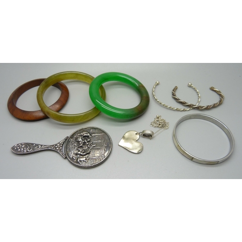 877 - Two jade bangles, a wooden bangle, a white metal mirror, three bangles and a pendant and chain