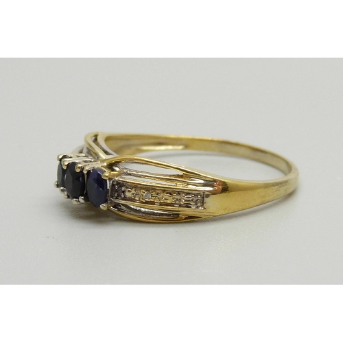 929 - A silver gilt and three sapphire ring with two small diamond accents on the shoulders, X