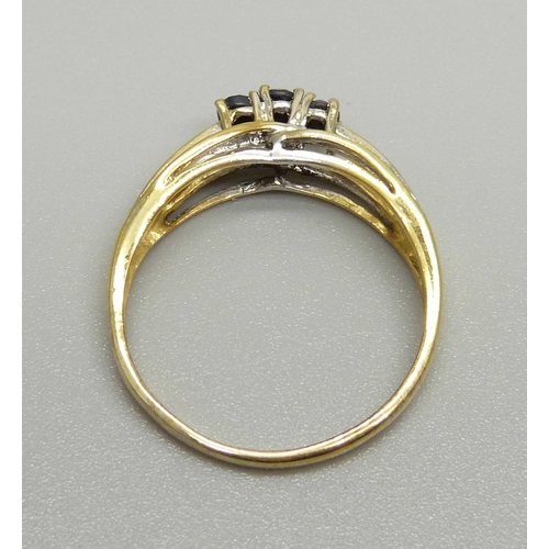 929 - A silver gilt and three sapphire ring with two small diamond accents on the shoulders, X