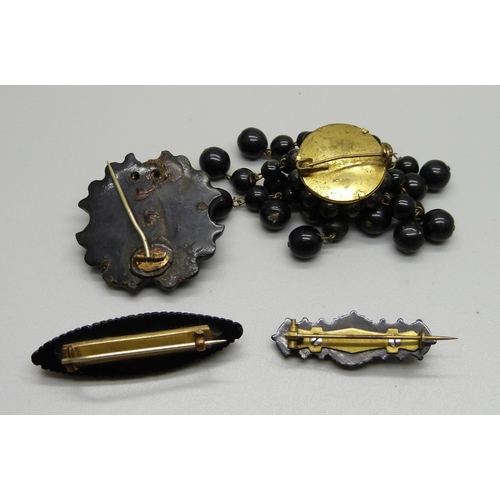 932 - Two Victorian carved jet brooches, leaf pattern and one set with stones, and two other brooches, ('s... 