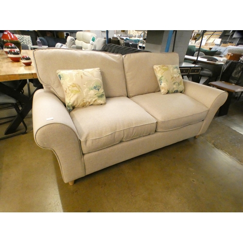 1416 - A light stone upholstered three seater sofa on turned legs