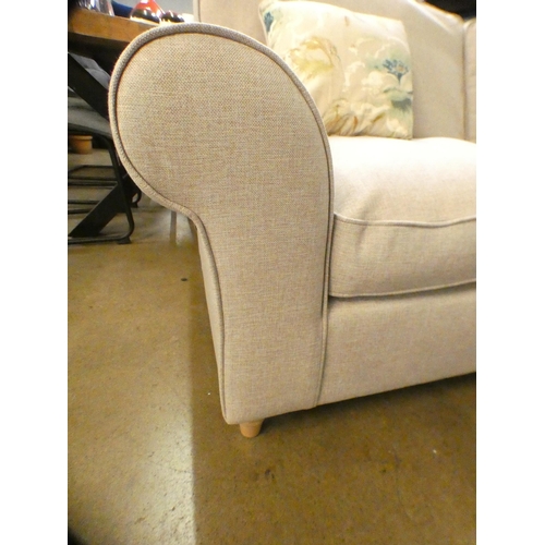 1416 - A light stone upholstered three seater sofa on turned legs