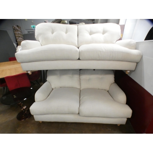 1434 - An ivory upholstered three and two seater sofa on turned legs