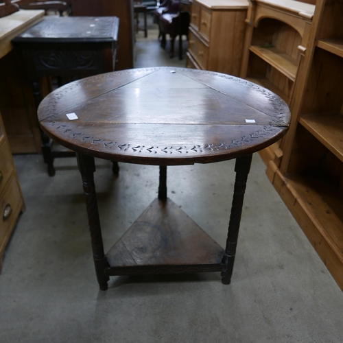 111 - A 17th Century style carved oak drop-leaf corner tavern table