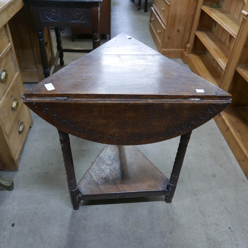 111 - A 17th Century style carved oak drop-leaf corner tavern table