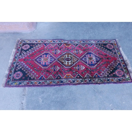 188 - An eastern red ground runner rug