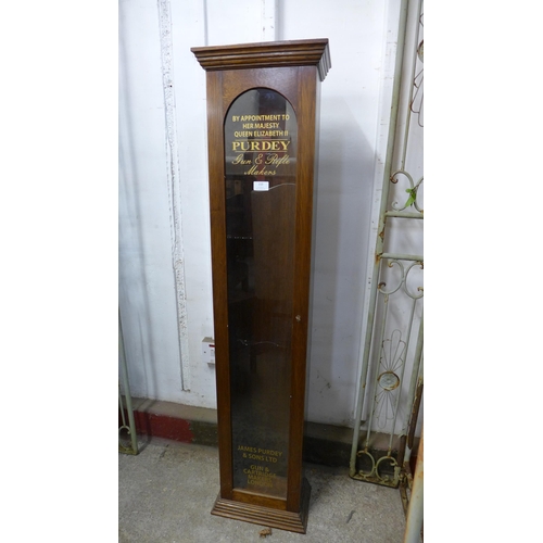 210 - A glazed oak single door cabinet, bearing Purdey Gun & Rifle Makers inscription to door