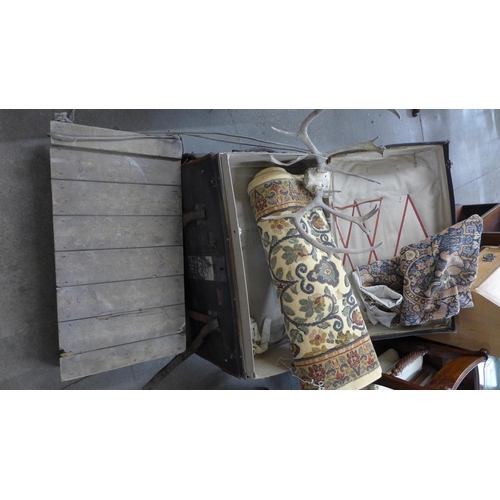 214 - A vintage steamer trunk, a pair of antlers, a brass stirrup pump, a sledge, a wall hanging and a rug