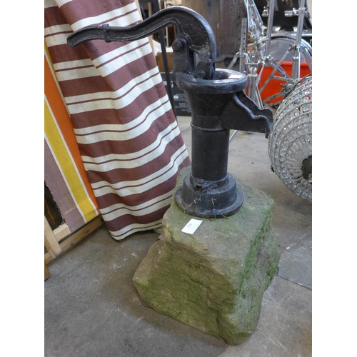 230 - A cast iron water pump, mounted on a stone block