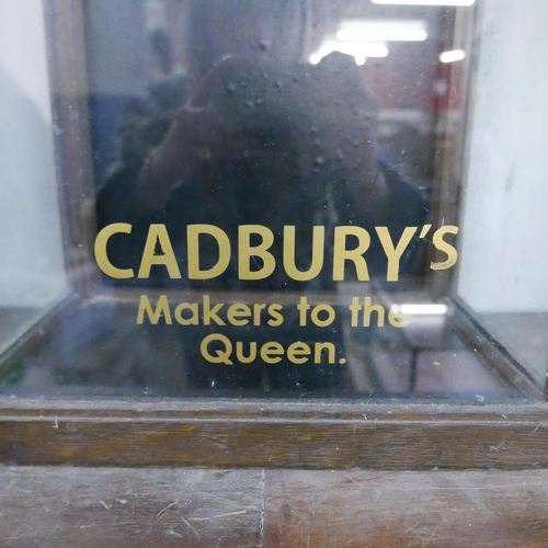 295 - An early 20th Century glazed oak counter top shop display cabinet, bearing Cadbury's inscription