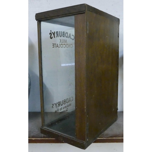 295 - An early 20th Century glazed oak counter top shop display cabinet, bearing Cadbury's inscription