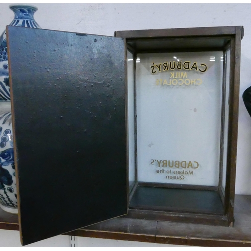 295 - An early 20th Century glazed oak counter top shop display cabinet, bearing Cadbury's inscription