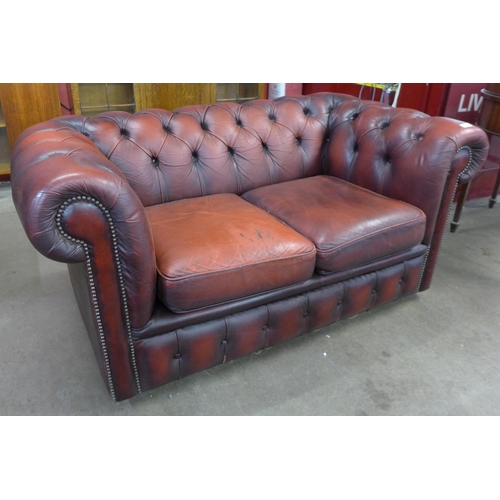 67 - An oxblood red leather Chesterfield settee