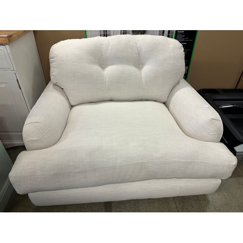 1573 - A white upholstered oversized armchair (tear to arm)