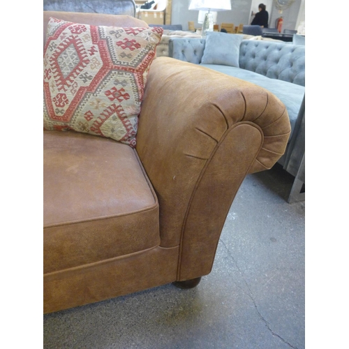 1496 - A tan vegan leather corner sofa and contrasting Aztec patterned footstool and scatter cushions