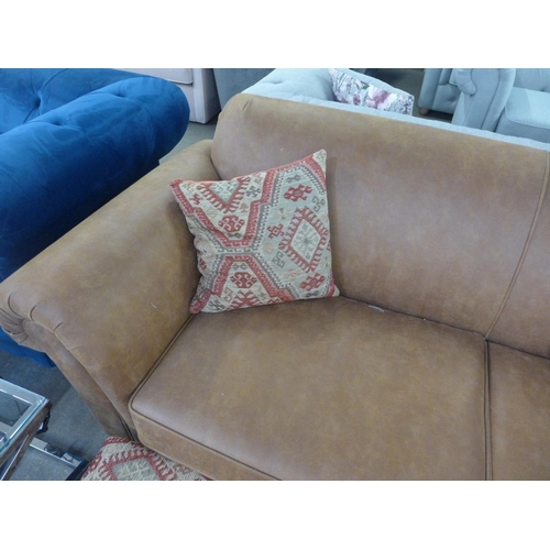 1496 - A tan vegan leather corner sofa and contrasting Aztec patterned footstool and scatter cushions